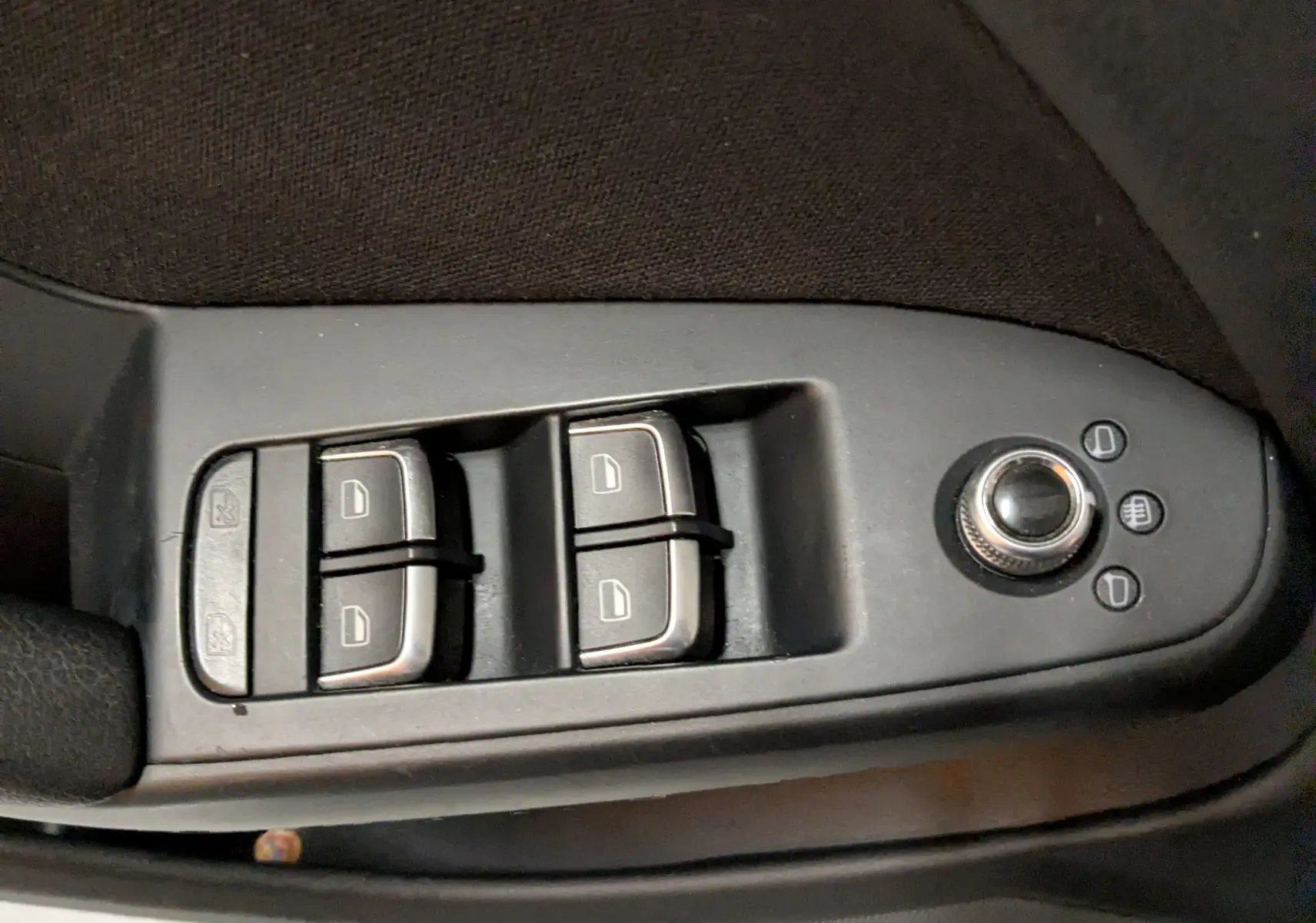 Commande des vitres électriques et réglage des rétroviseurs sur la porte côté conducteur d'une Audi A4 gris 2013.