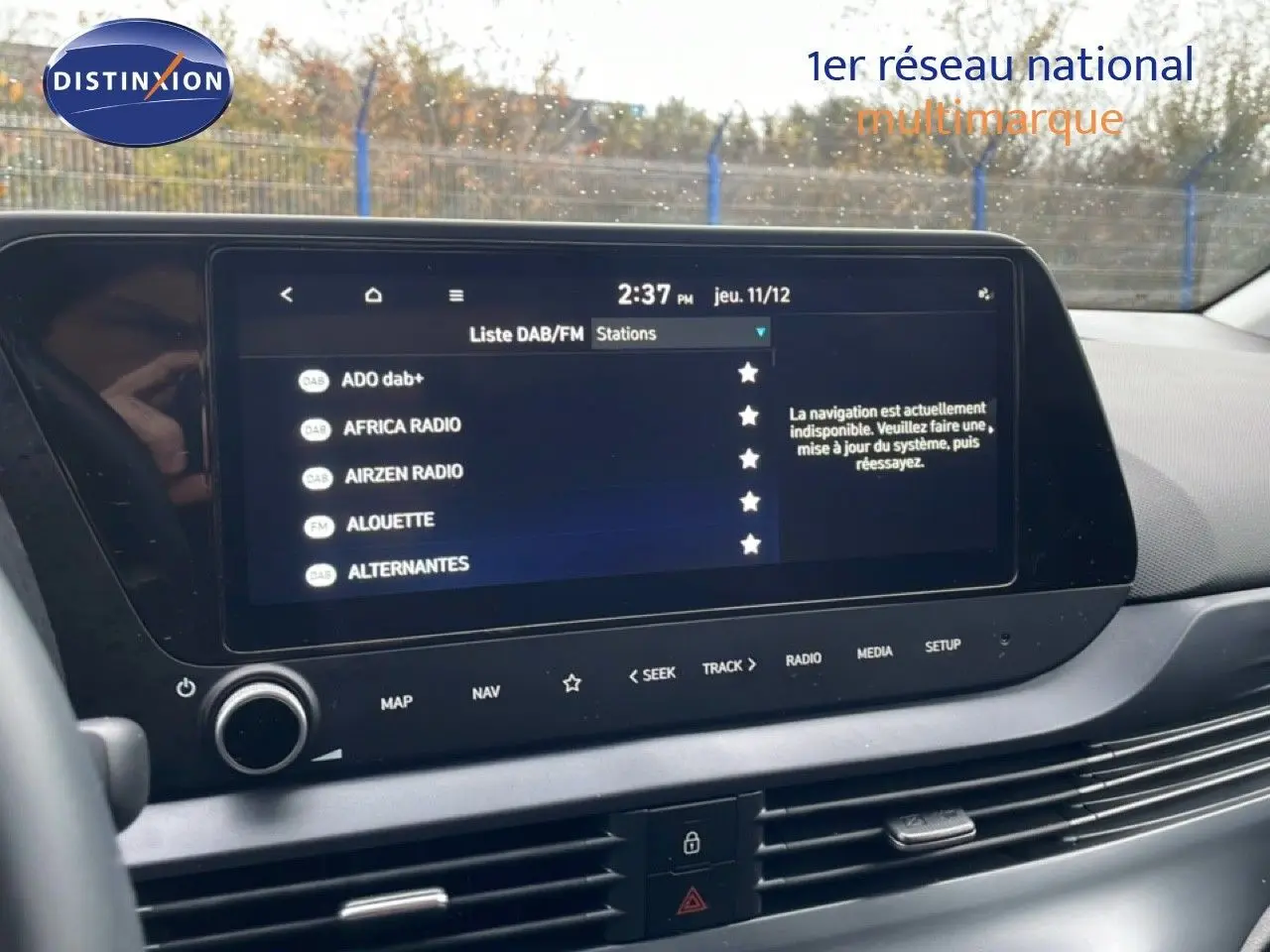 Écran tactile central de la Hyundai i20 2025 affichant la liste des stations radio DAB/FM en intérieur gris.