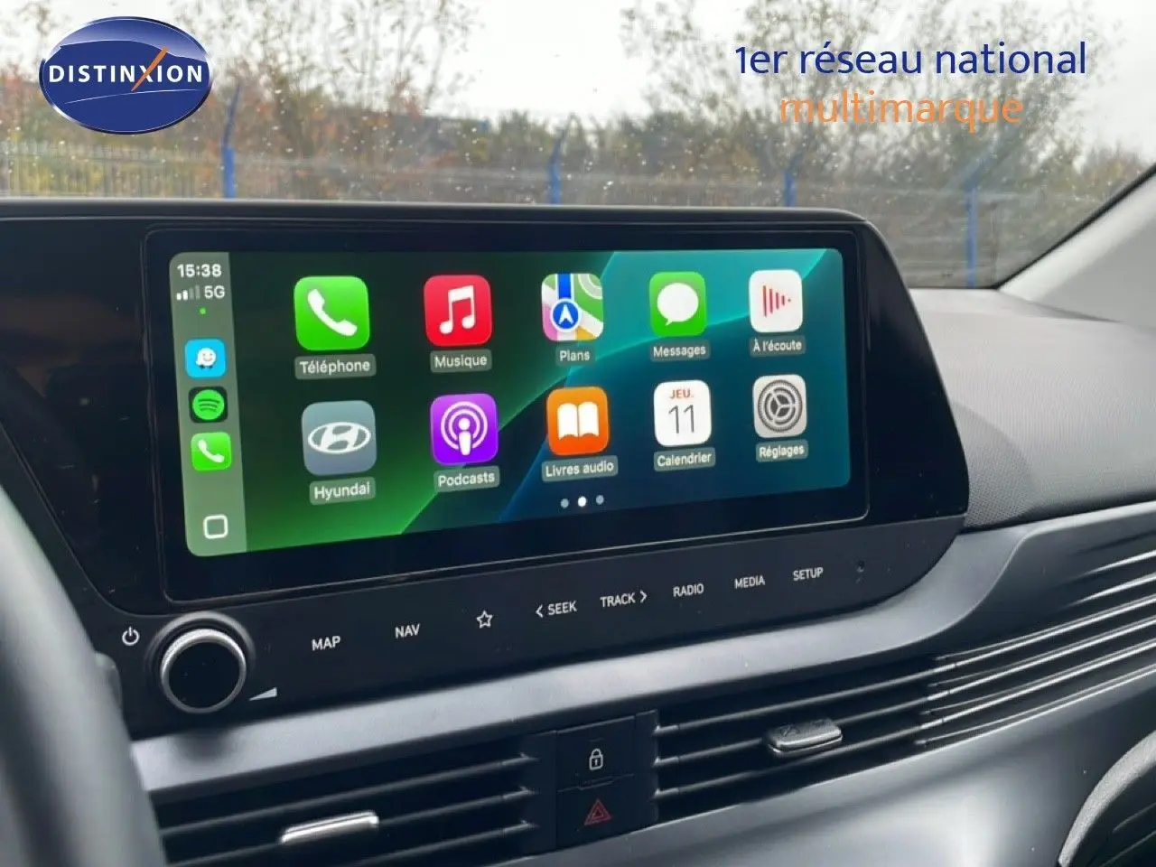 Écran tactile central de la Hyundai i20 2025 affichant les applications Apple CarPlay, vue intérieure côté conducteur.