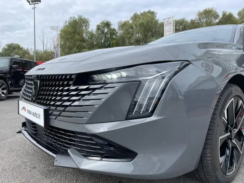 Vue 3/4 avant droit d'une Peugeot 508 SW gris Selenium avec calandre noire et phares LED distinctifs.