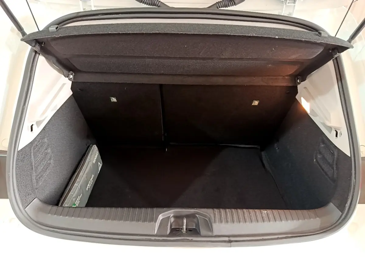 Coffre ouvert vu de face d’une Renault Clio Business blanche, montrant un espace de rangement propre et spacieux.
