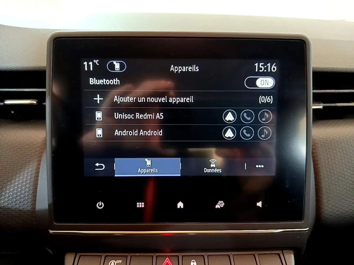 Écran tactile central de la Renault Clio Business blanc, affichant la connexion Bluetooth avec deux appareils listés.