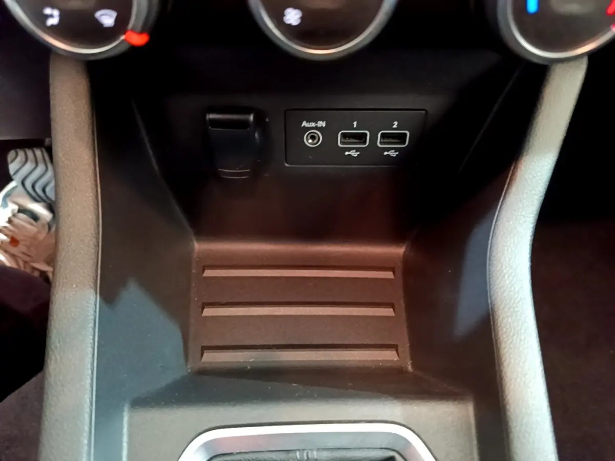 Vue rapprochée de la console centrale noire de la Renault Clio Business avec ports USB et prise Aux-In visibles.
