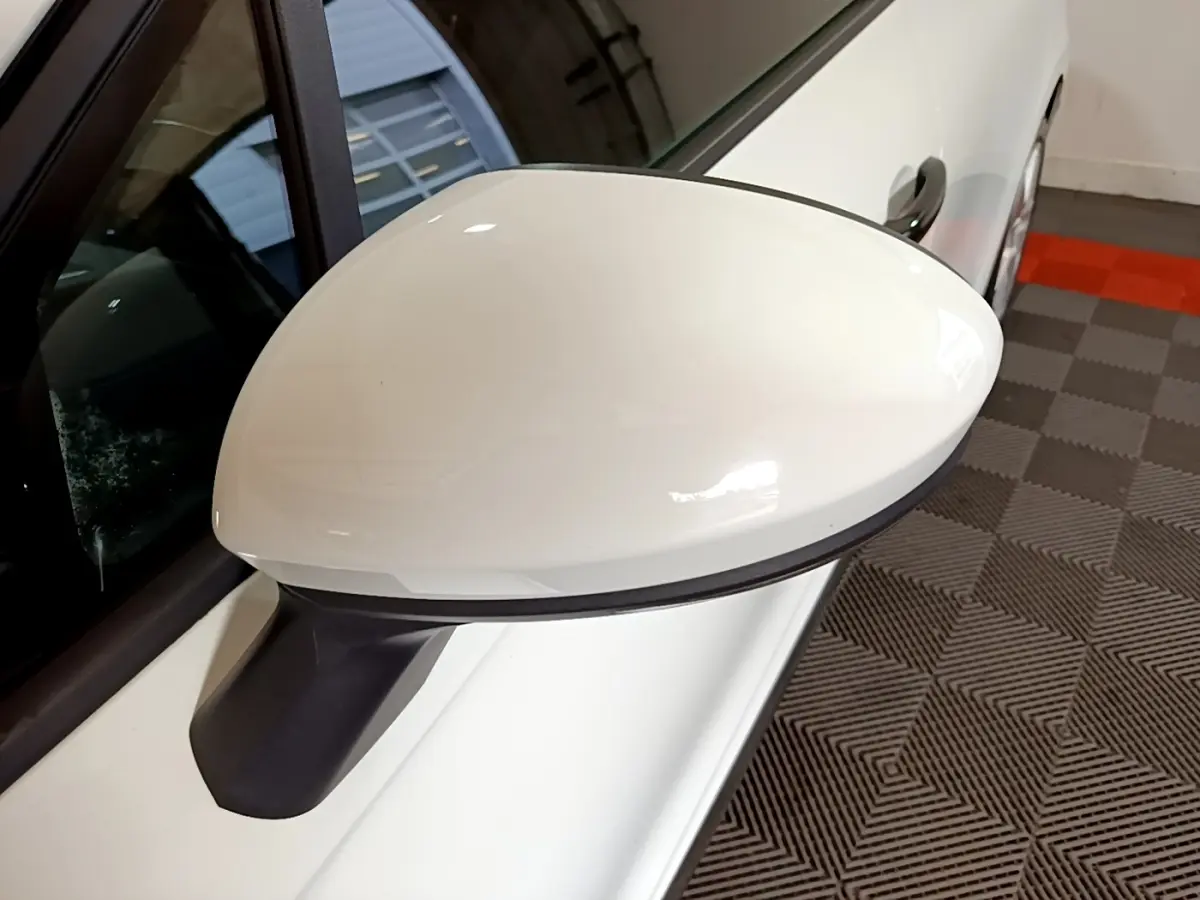 Rétroviseur côté gauche blanc d'une Renault Clio Business 2021, vue rapprochée avec porte et poignée visibles.