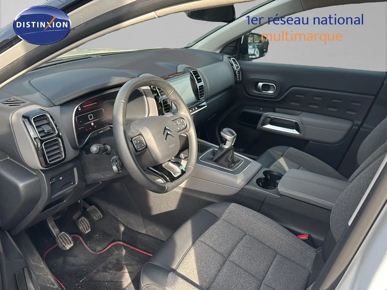 Intérieur côté conducteur du Citroën C5 Aircross blanc nacré, volant multifonction et levier de vitesse manuel visibles.