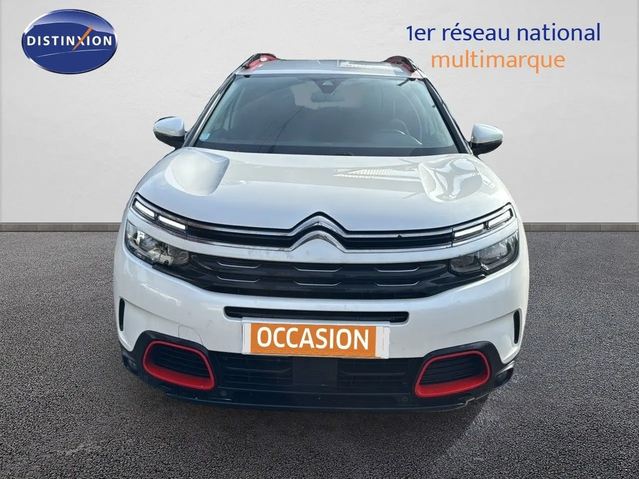 Vue de face d'un Citroën C5 Aircross blanc nacré avec détails rouges sur le pare-chocs et calandre noire.