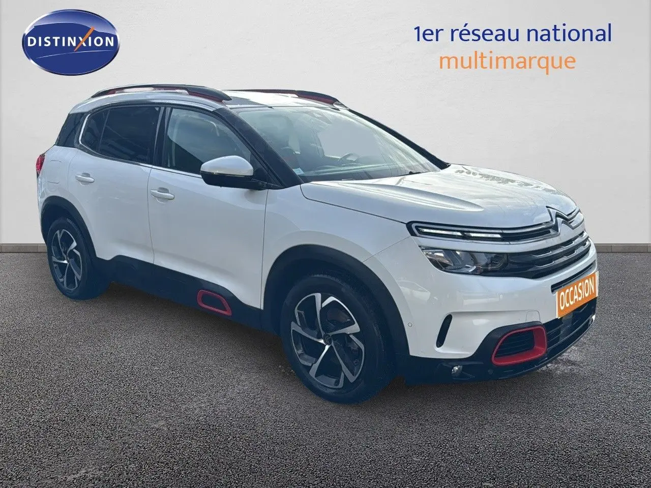 Citroën C5 Aircross blanc nacré en 3/4 avant droit avec jantes bi-ton et inserts rouges distinctifs.