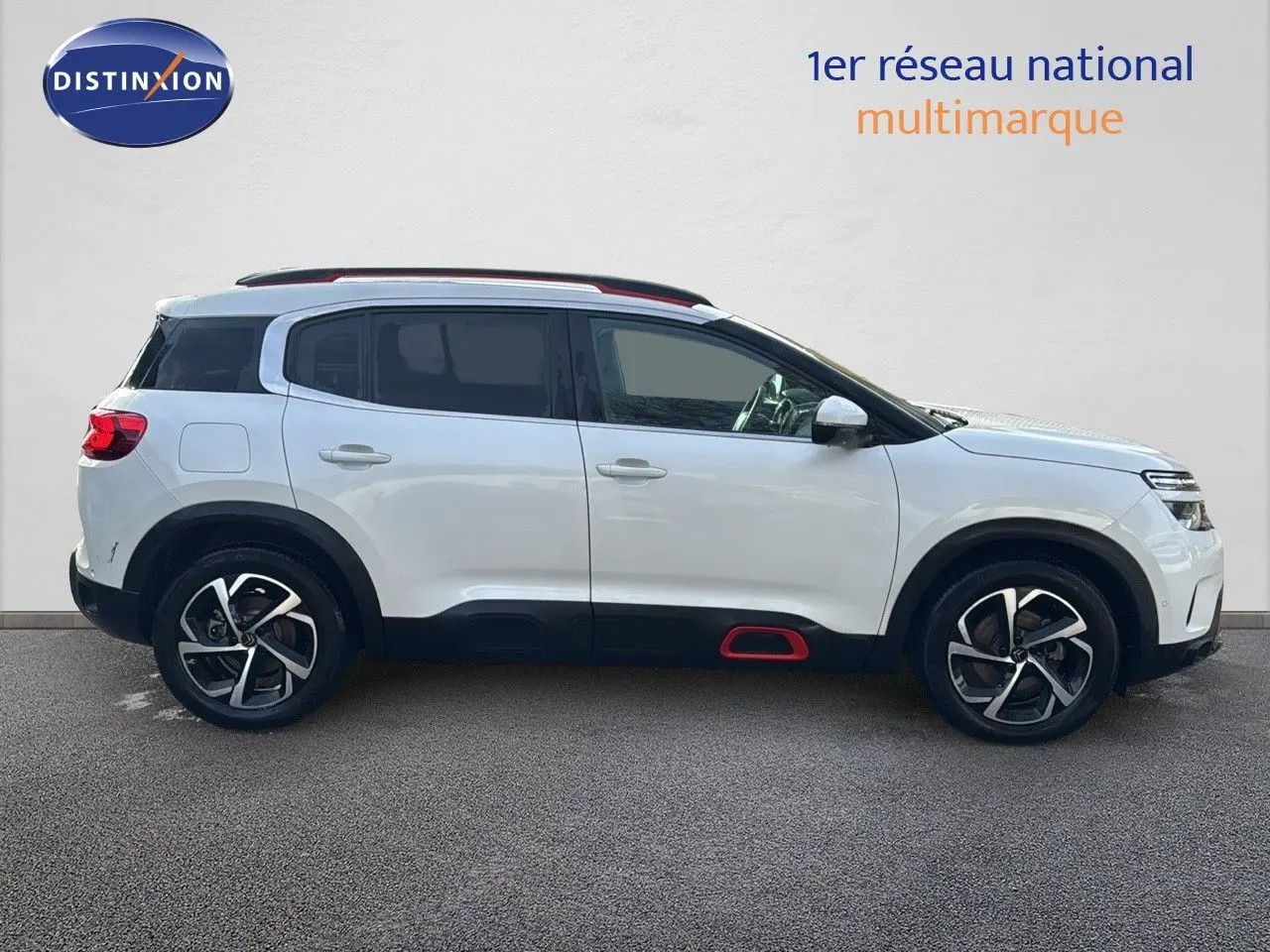 Profil droit d’un Citroën C5 Aircross blanc nacré avec jantes bi-ton et détails rouges sur bas de caisse.