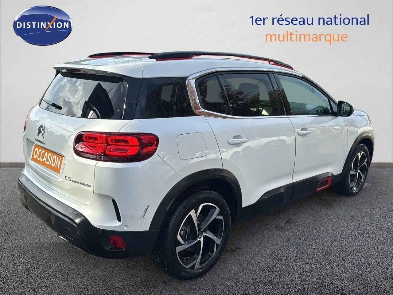 Vue 3/4 arrière droite d’un Citroën C5 Aircross blanc nacré avec jantes bi-ton et toit noir.