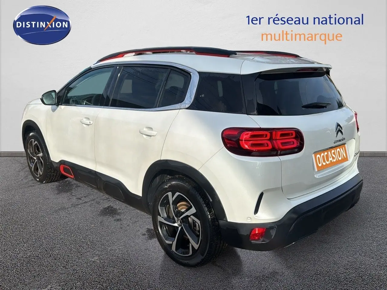 Vue 3/4 arrière droite d'un Citroën C5 Aircross blanc nacré avec jantes bi-ton et détails rouges sur les bas de caisse.