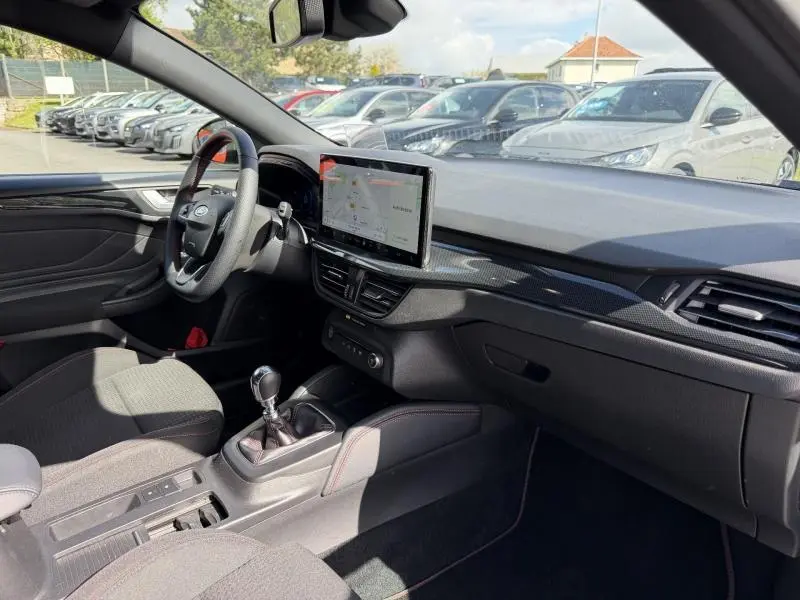 Intérieur de la Ford Focus SW 2023 vu côté conducteur, tableau de bord avec écran tactile et volant multifonction.