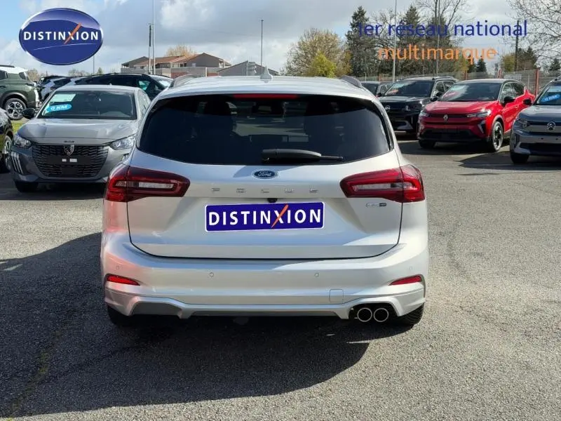Vue arrière d'une Ford Focus SW 2023 gris lunaire métallisé avec double sortie d'échappement et logo ST-Line X visible.
