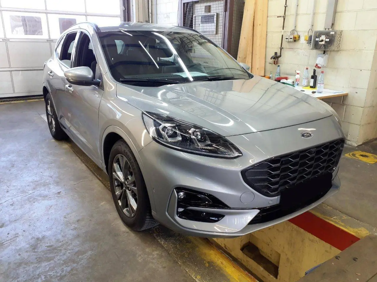 Ford Kuga 2024 gris Solar en 3/4 avant droit, avec calandre noire et jantes alliage 18 pouces ST-Line.