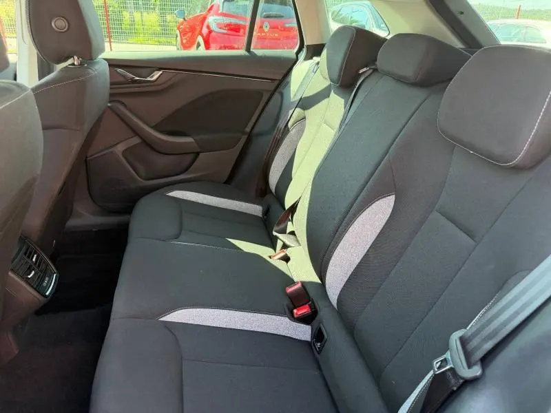 Vue intérieure côté droit de la banquette arrière noire et grise du Skoda Scala 2025 avec ceinture de sécurité visible.