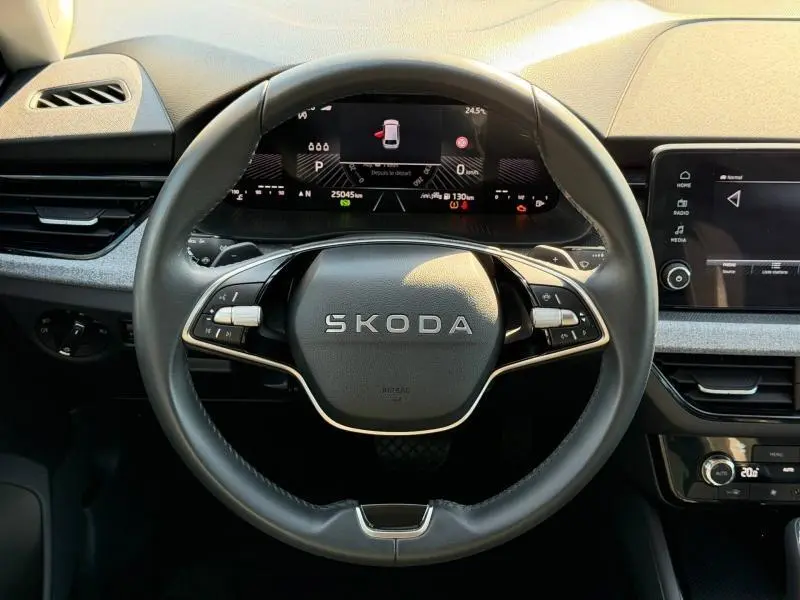 Vue intérieure centrée sur le volant cuir multifonction Skoda SCALA 2025 avec tableau de bord numérique et écran tactile.