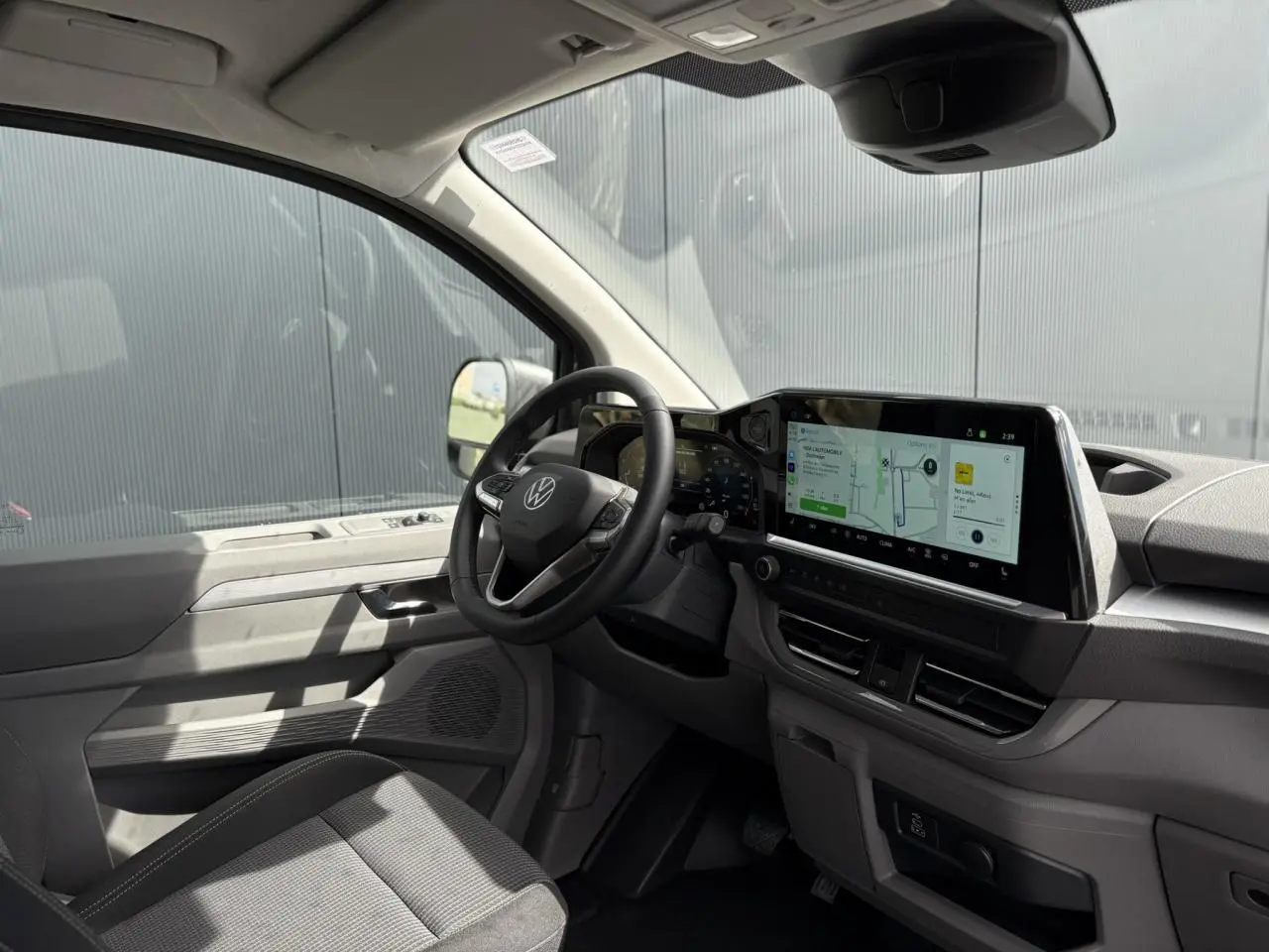 Vue intérieure côté conducteur du Volkswagen Transporter T7 ProCab 2026, tableau de bord moderne avec écran tactile large.