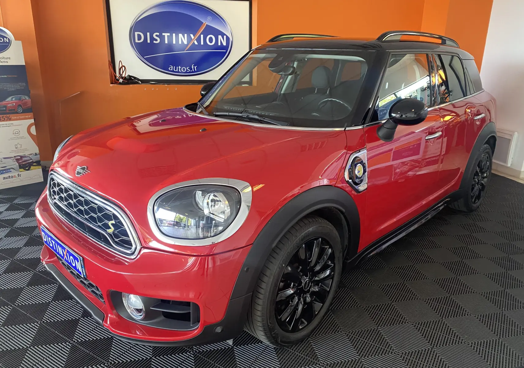 MINI Countryman Cooper SSE hybride rouge avec toit noir, vue 3/4 avant droit, jantes noires et barres de toit visibles.