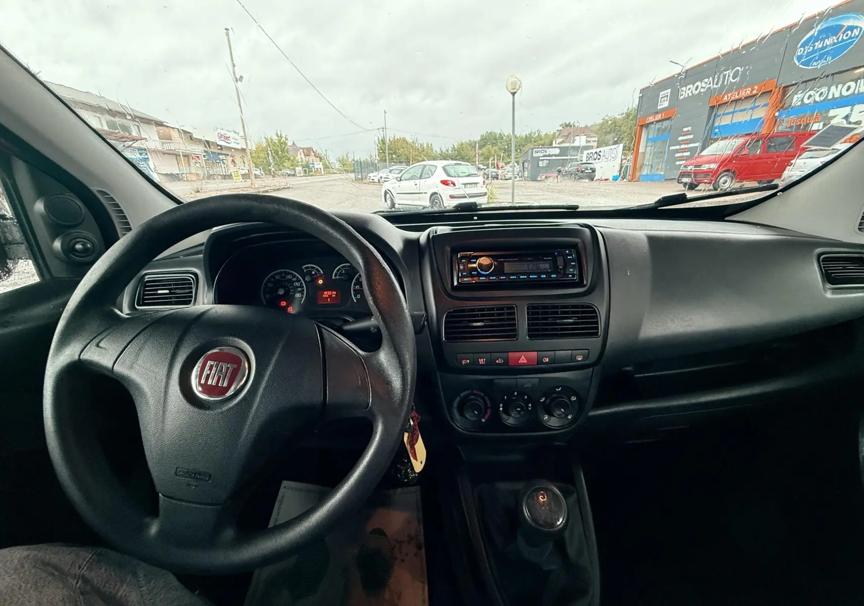 Vue intérieure du tableau de bord et volant du Fiat Doblo Cargo 2011, avec commande manuelle et autoradio visible.