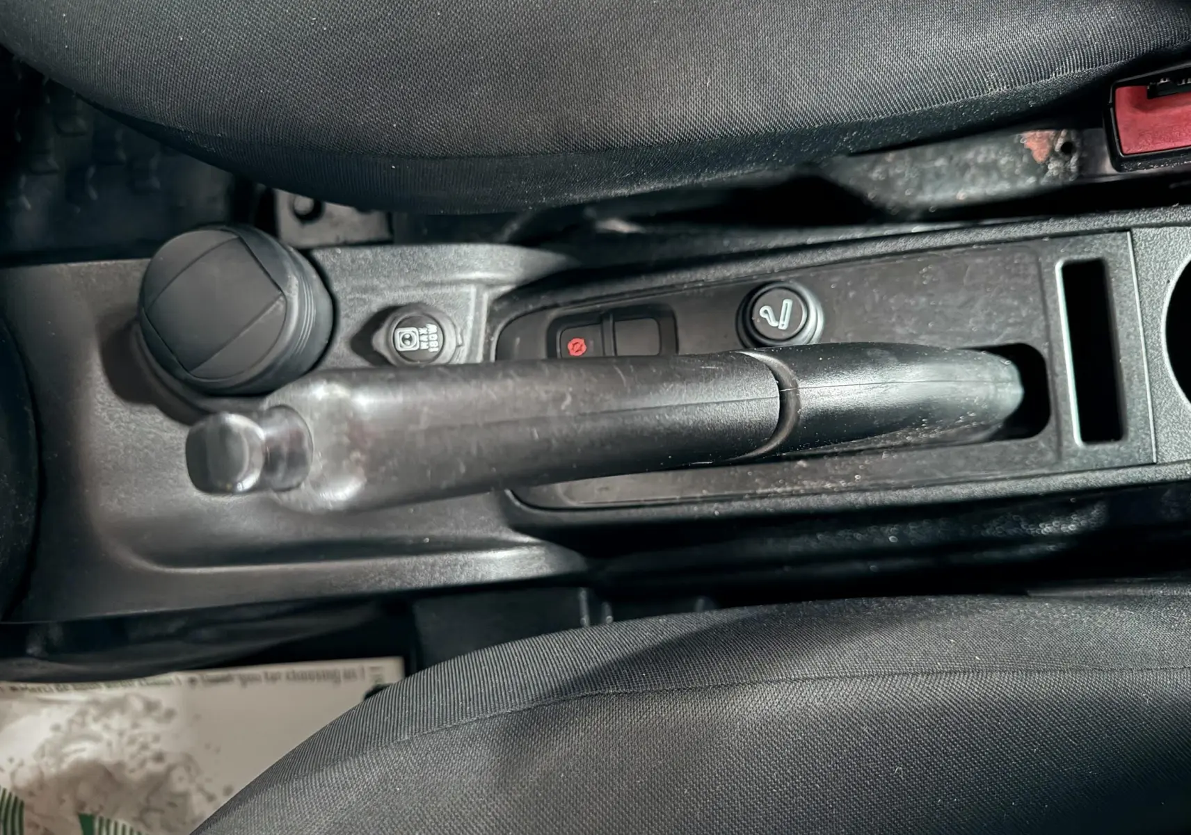 Vue rapprochée de la console centrale du Fiat Doblo Cargo 2011, montrant le frein à main et les commandes noires.