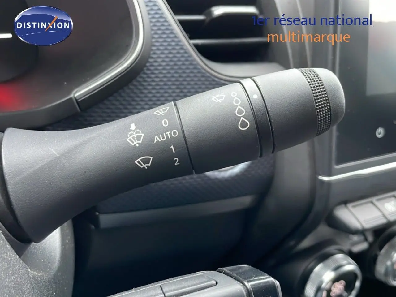 Gros plan sur la manette d'essuie-glace noire à gauche du volant dans l'habitacle du Renault Arkana bleu Zanzibar 2025.