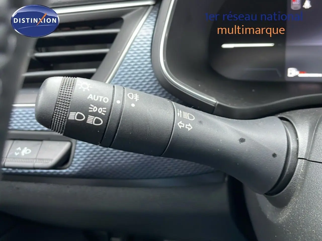 Gros plan sur la commande des feux et clignotants dans l’habitacle du Renault Arkana bleu Zanzibar Métal.