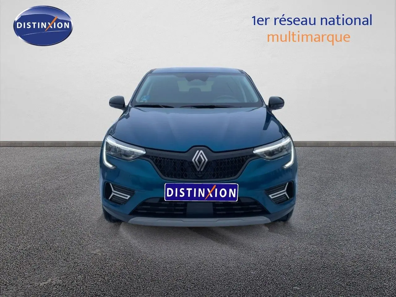 Vue de face du Renault Arkana bleu Zanzibar métal avec calandre noire et feux LED allumés sur fond neutre.