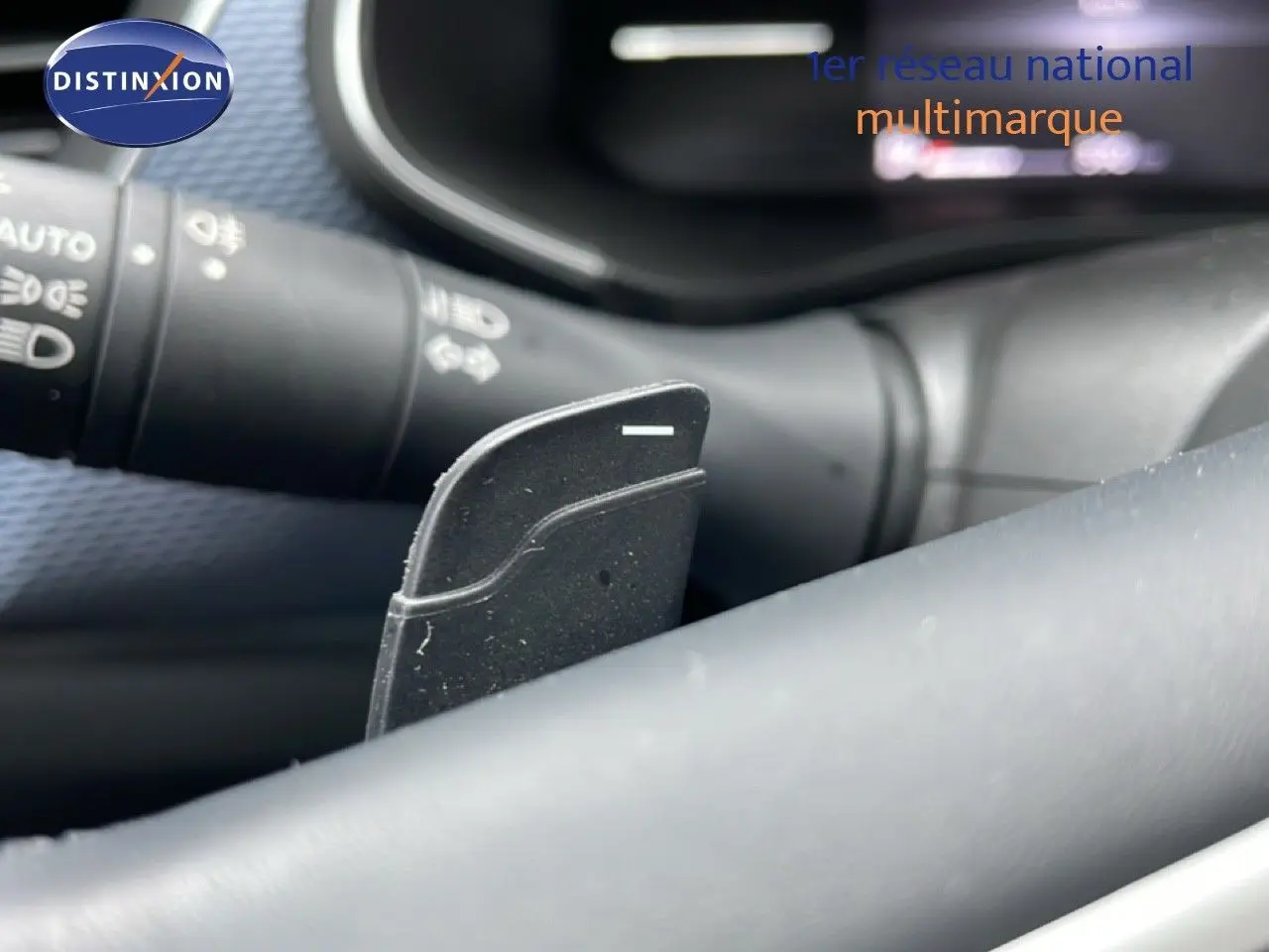 Gros plan sur la palette de changement de vitesse derrière le volant d’un Renault Arkana 2025, intérieur noir.