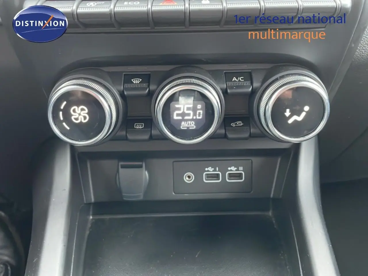 Gros plan sur la console centrale avec commandes de climatisation et ports USB du Renault Arkana bleu Zanzibar 2025.