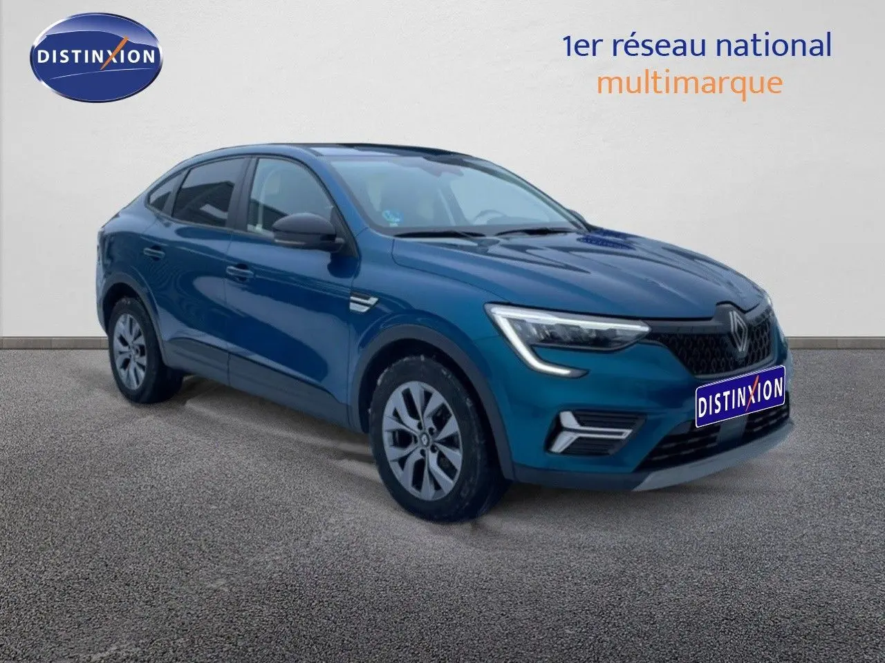 Renault Arkana bleu Zanzibar en 3/4 avant droit, SUV hybride avec calandre noire et jantes alliage.