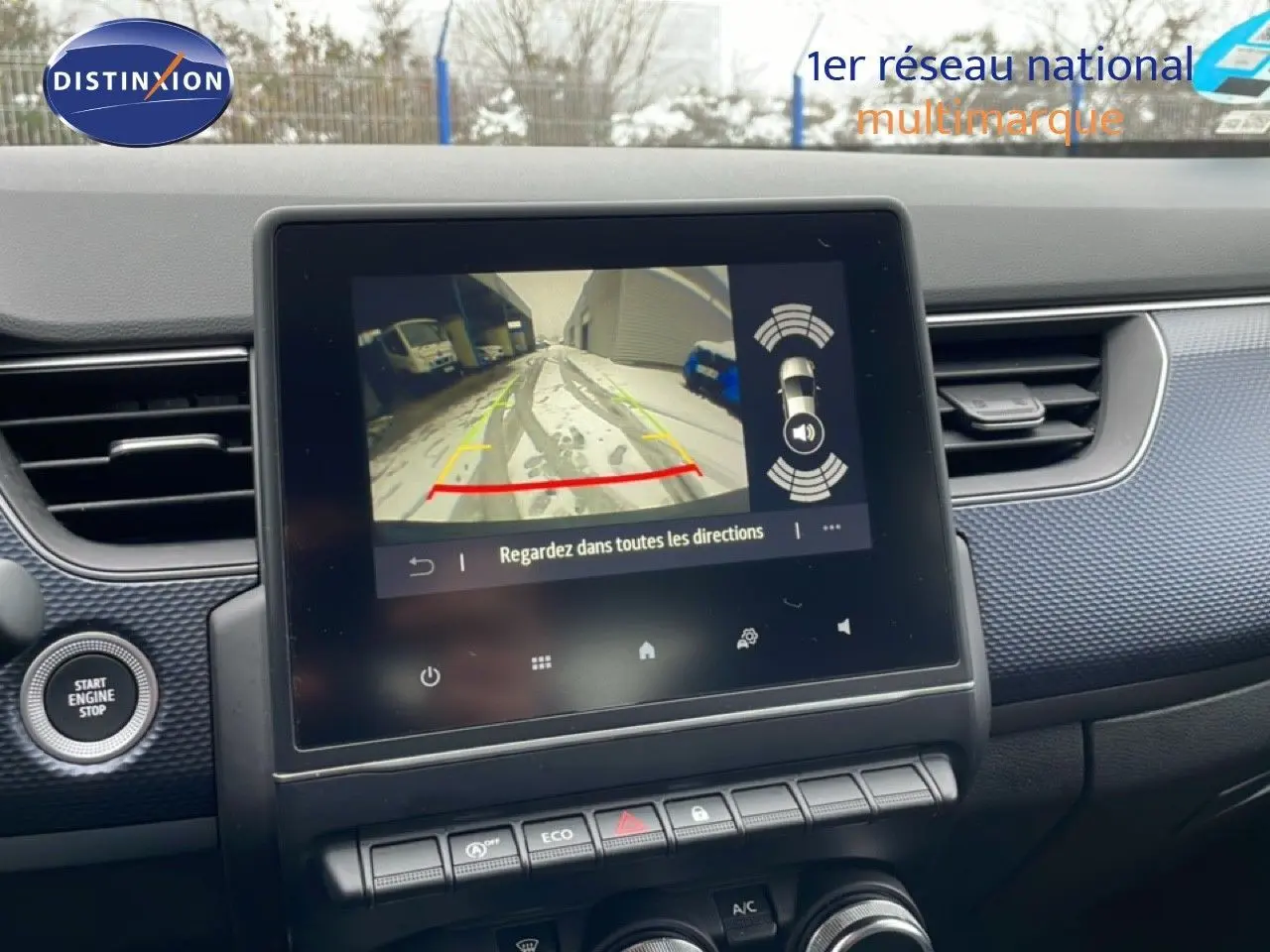 Vue rapprochée de l’écran central du Renault Arkana bleu Zanzibar, affichant la caméra de recul avec guidage dynamique.