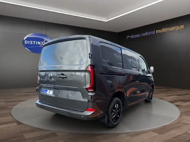 Vue 3/4 arrière droite du Volkswagen Transporter ProCab gris métallisé avec jantes alliage noires et vitres latérales teintées.