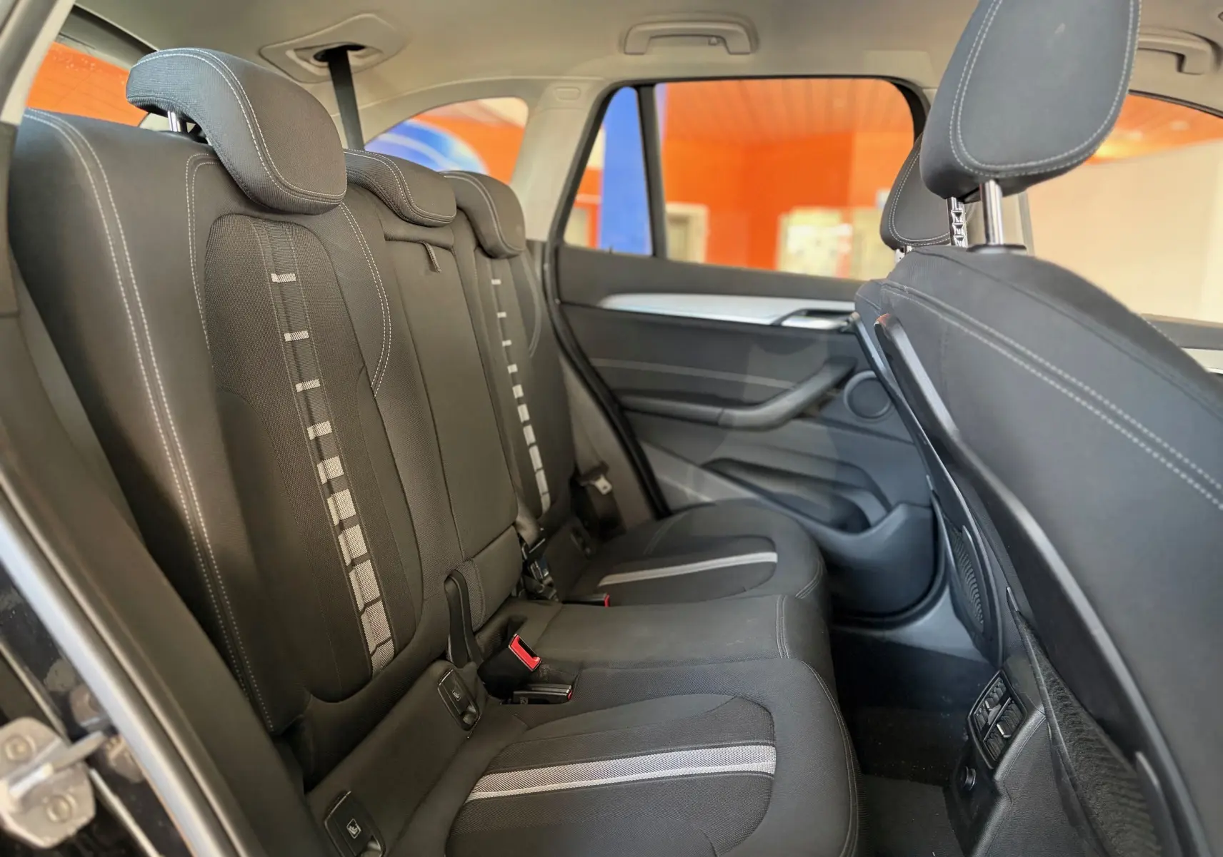 Vue intérieure côté droit des sièges arrière noirs en tissu du BMW X1 20i S-DRIVE SPORT LINE 2018.