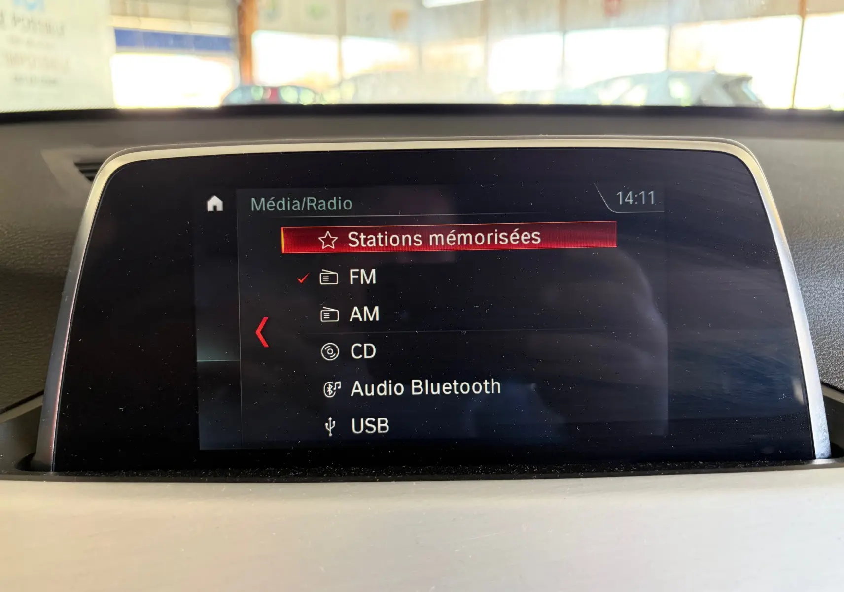 Écran central du système multimédia de la BMW X1 20i noir, affichant les options radio et Bluetooth.