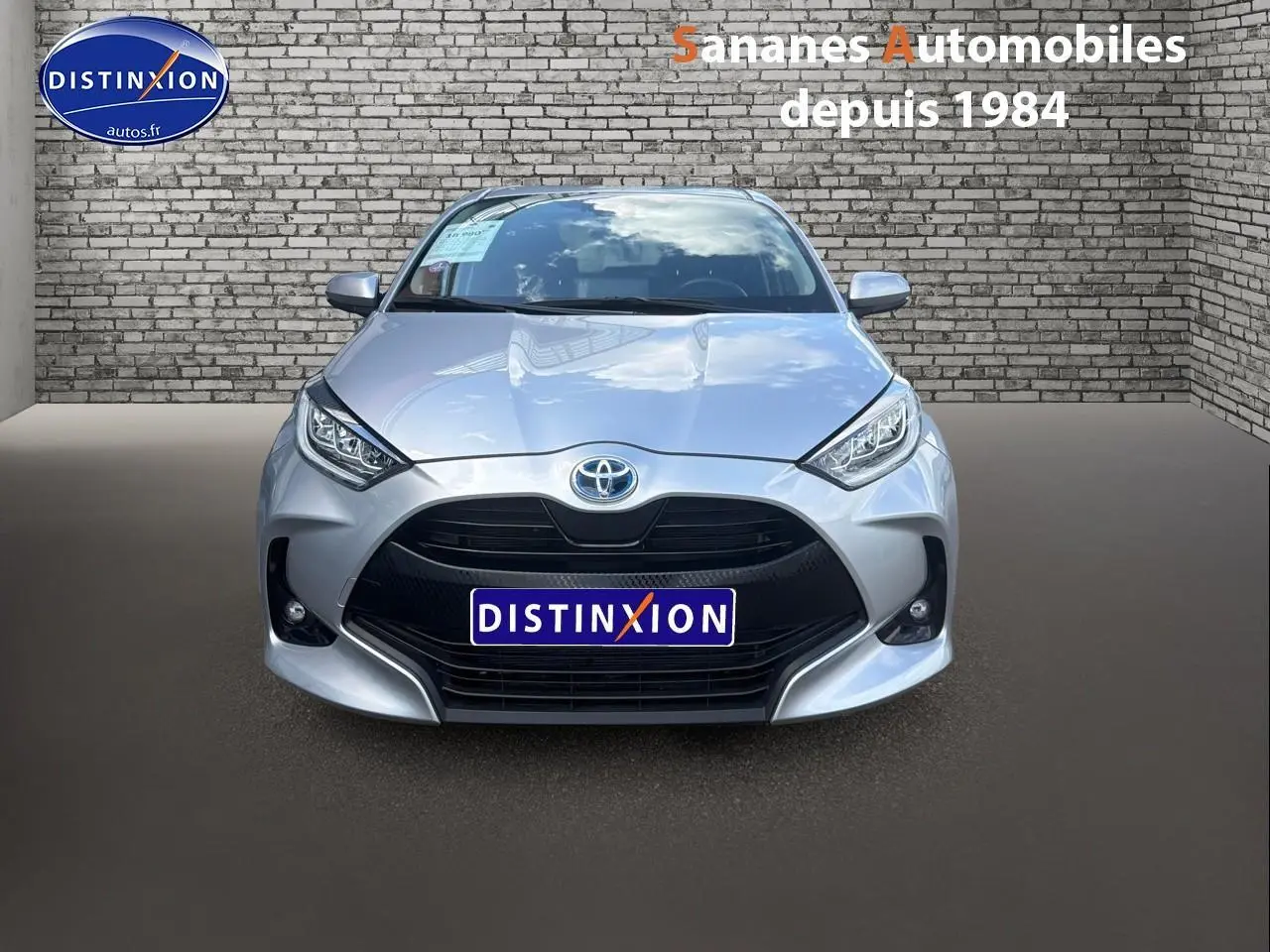 Vue avant d'une Toyota Yaris Hybrid 116h 2023 en peinture métallisée argentée, avec calandre noire et phares LED.