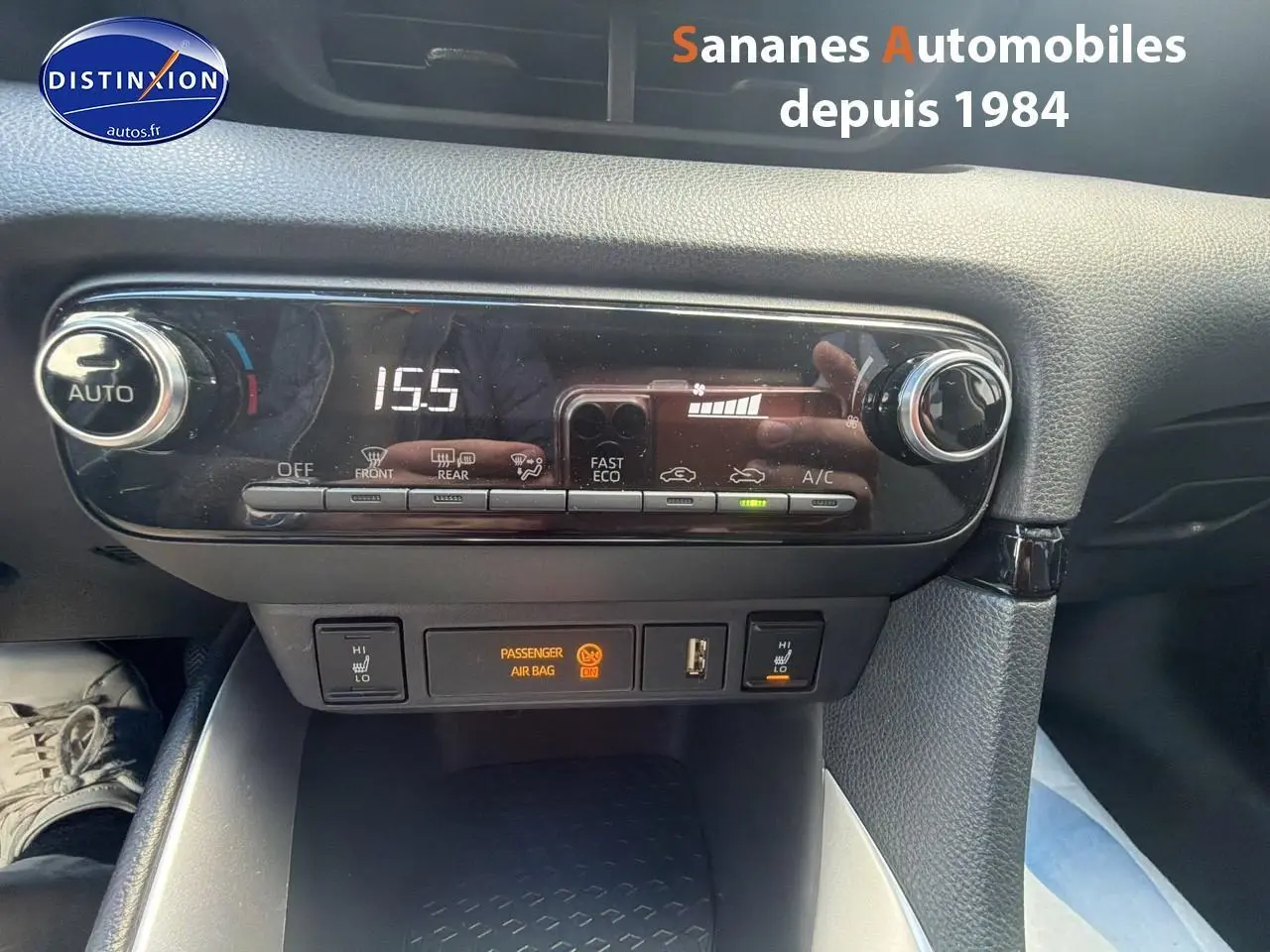 Vue rapprochée du tableau de bord de la Toyota Yaris Hybrid 2023 montrant la climatisation automatique et les commandes des sièges chauffants.