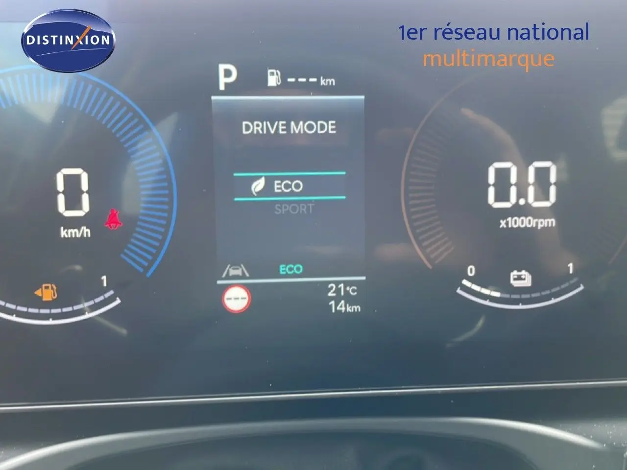 Gros plan sur le tableau de bord numérique du Hyundai Tucson blanc, affichant le mode de conduite Eco et la vitesse à 0 km/h.