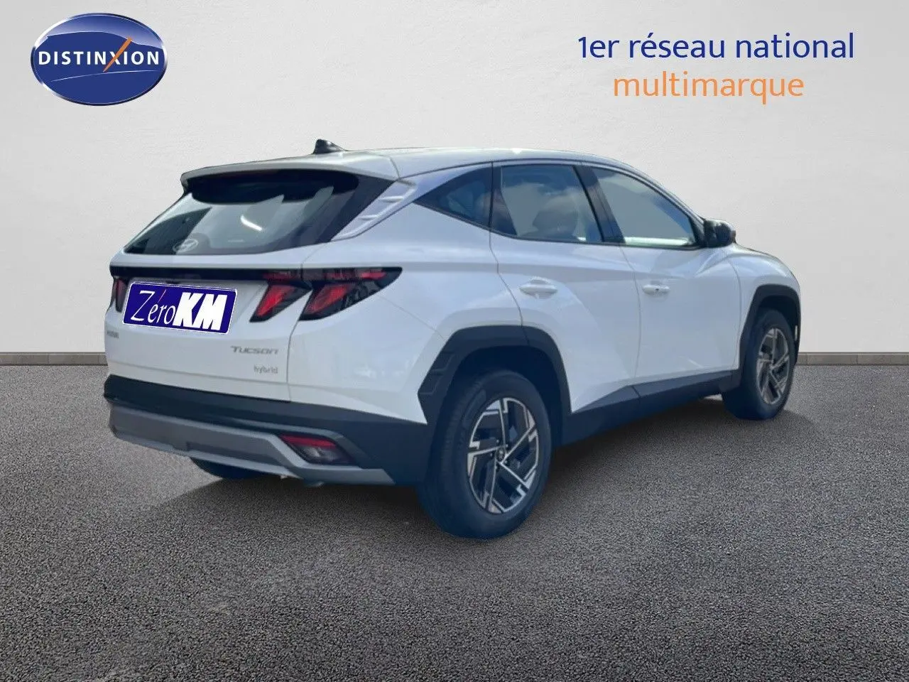 Vue 3/4 arrière droite d'un Hyundai Tucson blanc Atlas 2026 avec feux arrière LED et jantes bi-ton.