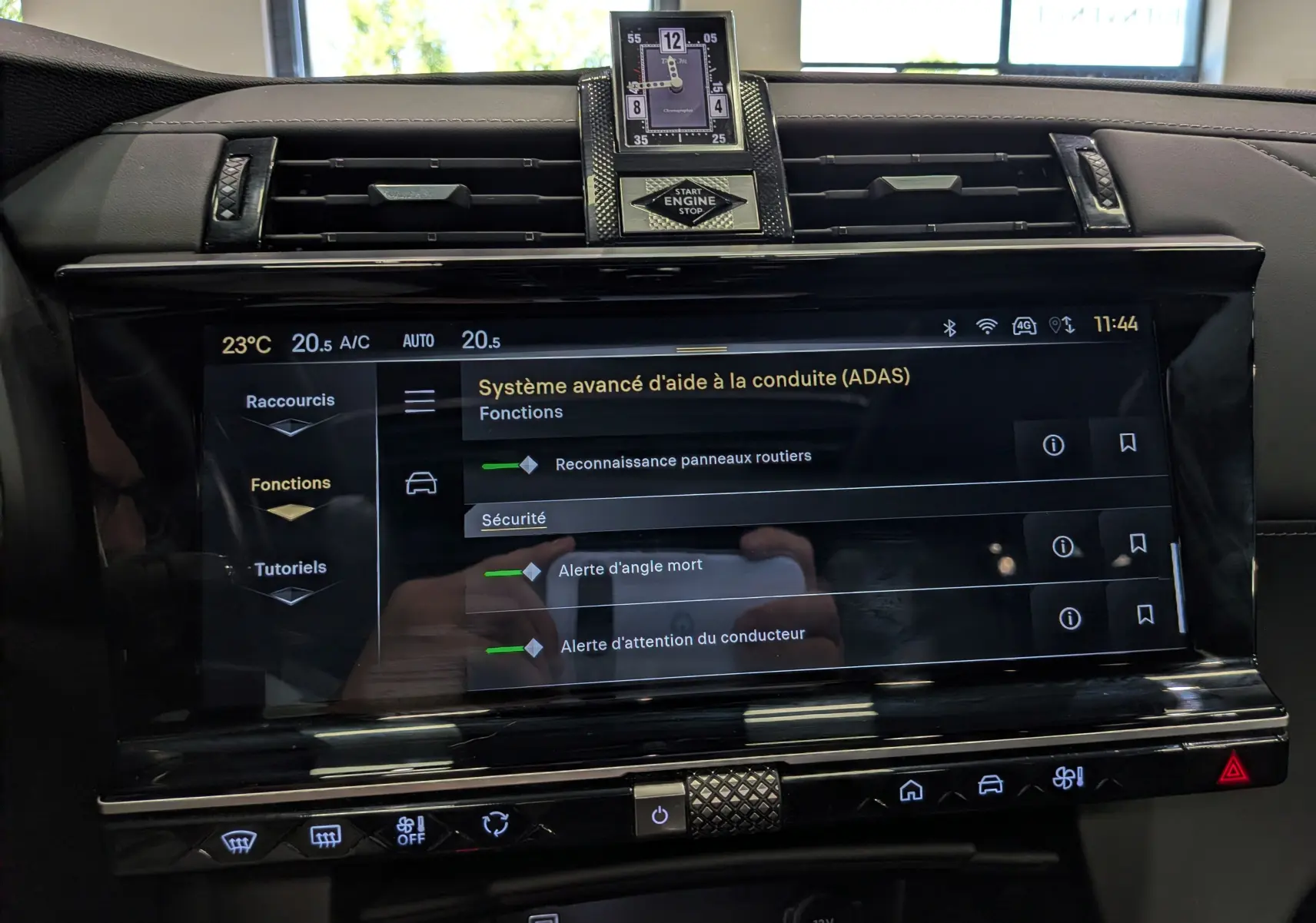 Vue rapprochée de l’écran tactile central du DS7 2024 gris, affichant les aides à la conduite et l’horloge digitale.