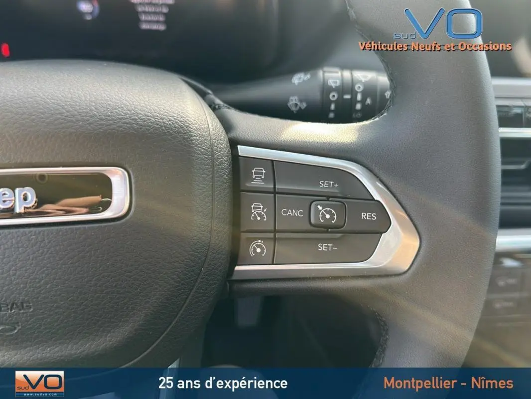 Gros plan sur la partie droite du volant noir du Jeep Compass 2024 avec commandes du régulateur de vitesse visibles.