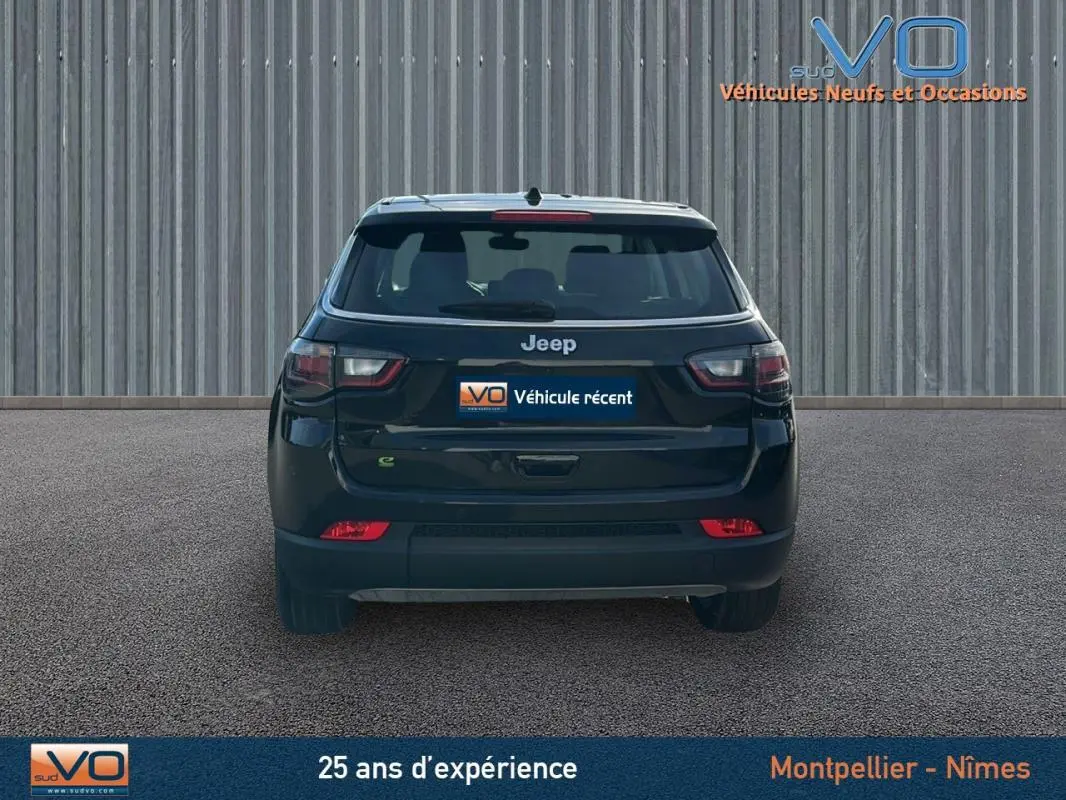 Vue arrière d'un Jeep Compass noir 2024 avec feux LED et logo Jeep bien visible sur un sol goudronné.