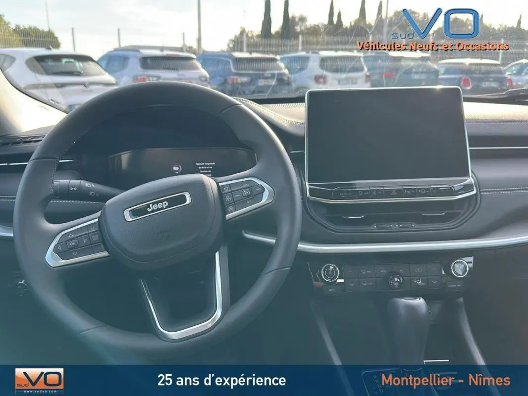 Intérieur du Jeep Compass 2024 montrant le volant multifonction et l'écran tactile central sur tableau de bord noir.