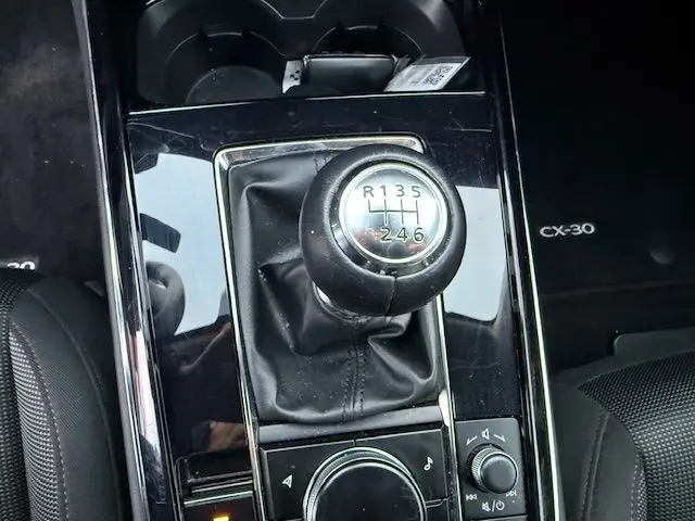 Gros plan sur la commande de boîte manuelle noire du Mazda CX-30 Polymetal Grey 2024, avec logo CX-30 visible à droite.