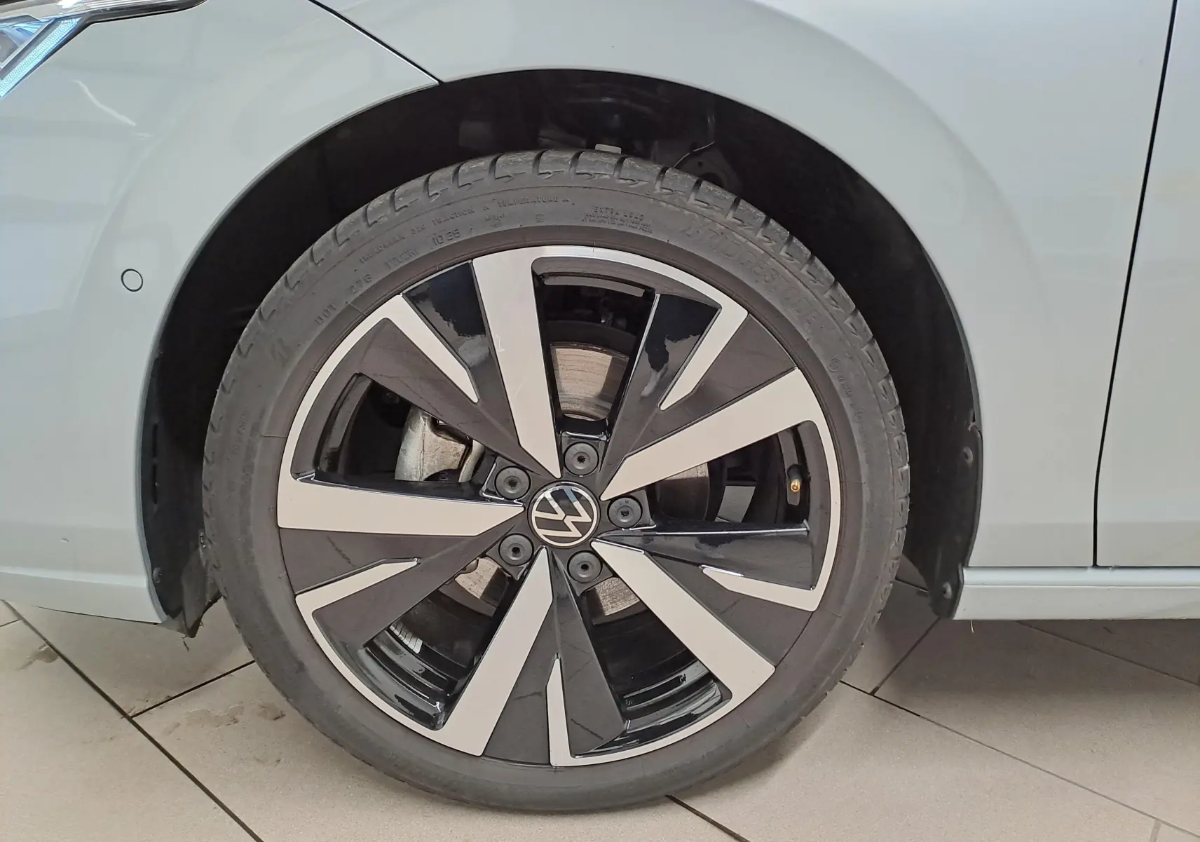 Gros plan sur la jante alliage 18'' Catania bicolore d'une Volkswagen Golf argent Dolomite côté avant droit.