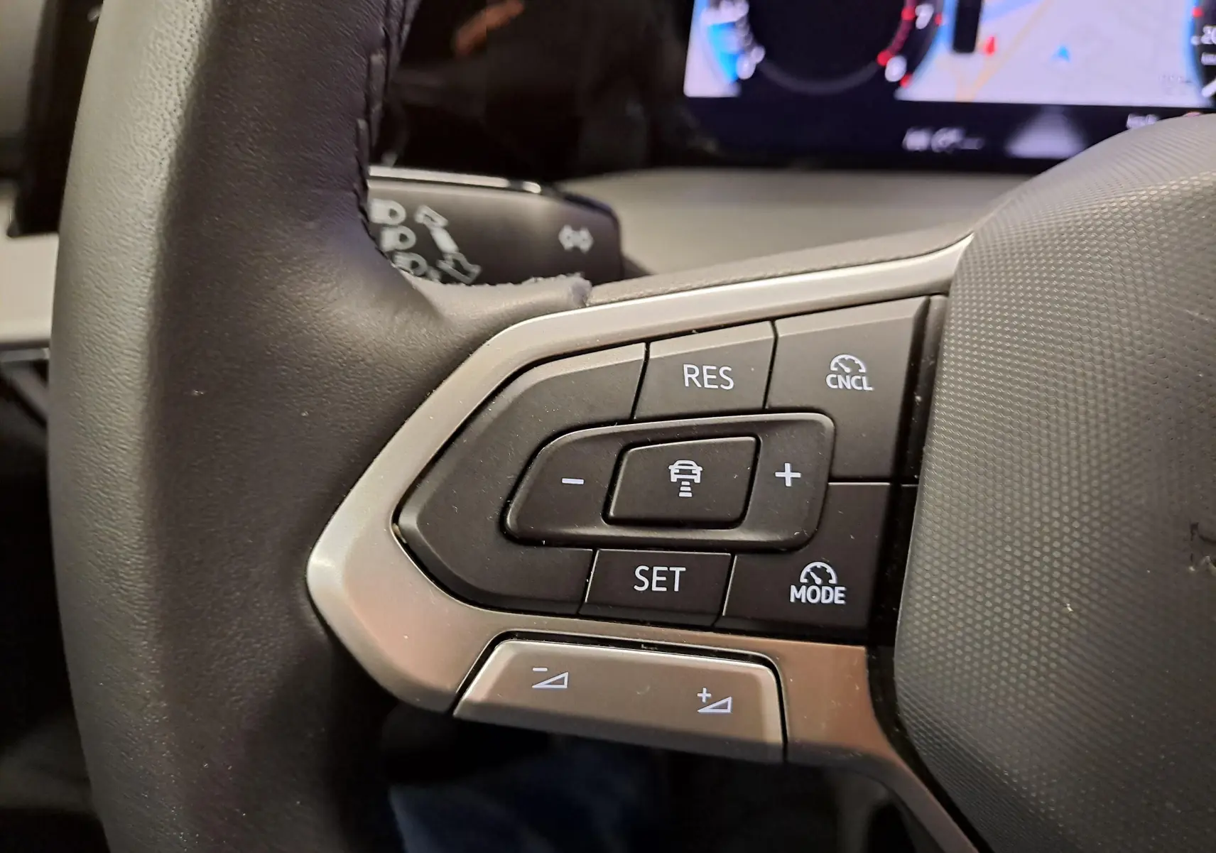 Gros plan sur les commandes du volant côté gauche d'une Volkswagen Golf 1.5 TSI 2025, finition VW Edition.