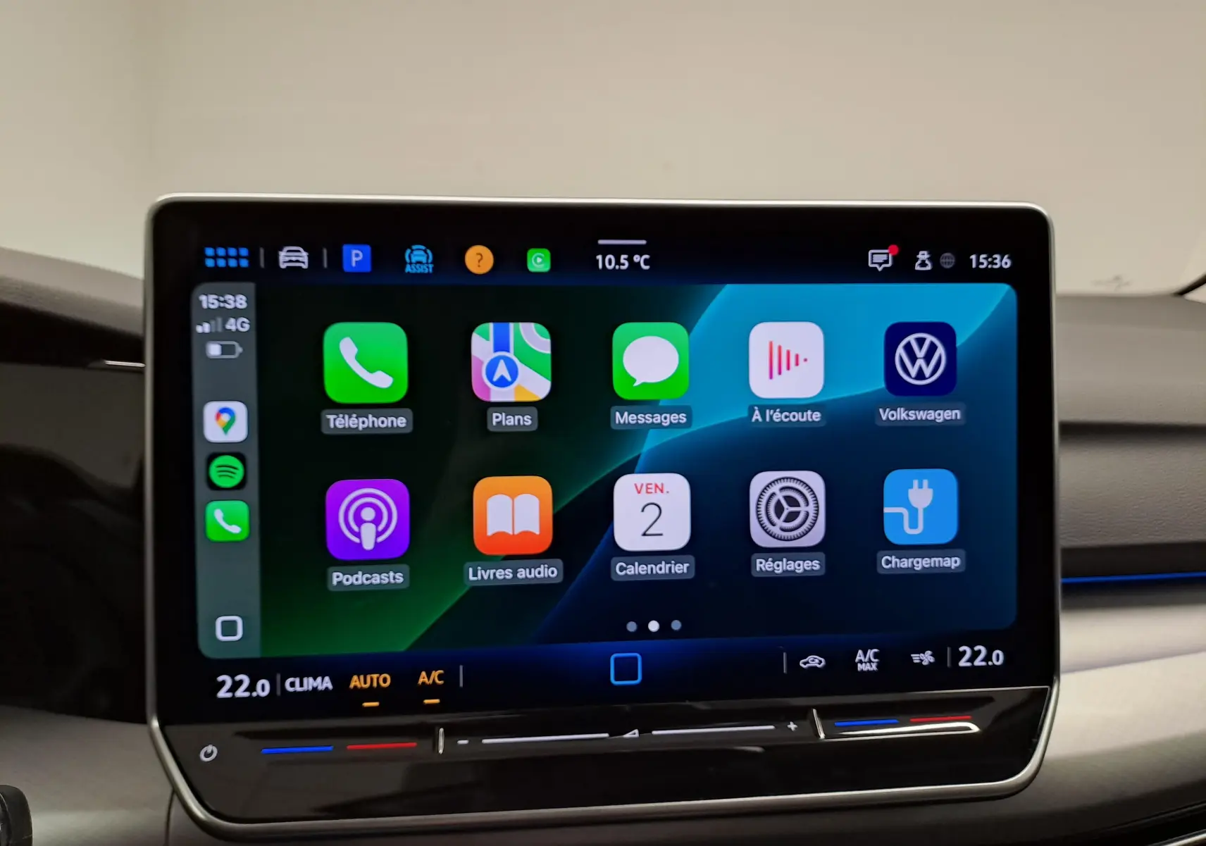 Écran tactile central de la Volkswagen Golf 2025 affichant des applications connectées, avec commandes climatisation intégrées.