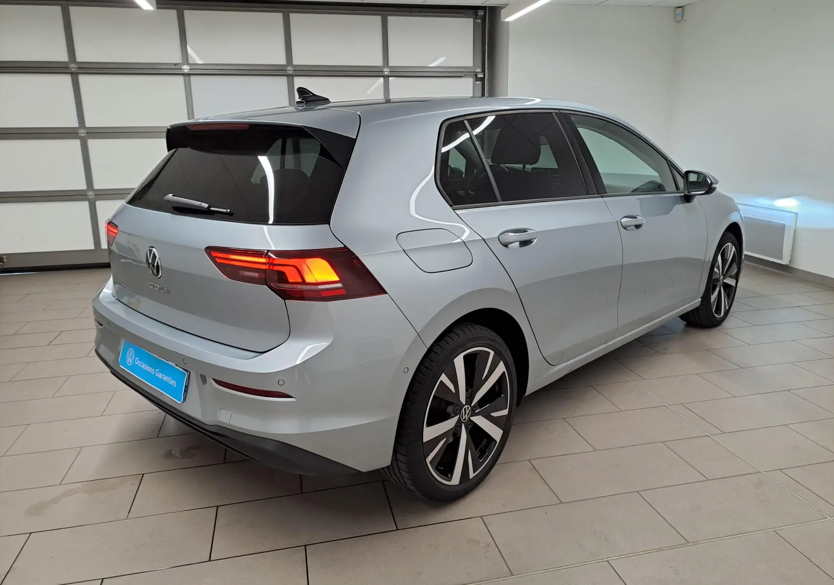 Volkswagen Golf 1.5 TSI 2025 en Argent Dolomite, vue 3/4 arrière droit avec jantes alliage 18 pouces Catania.