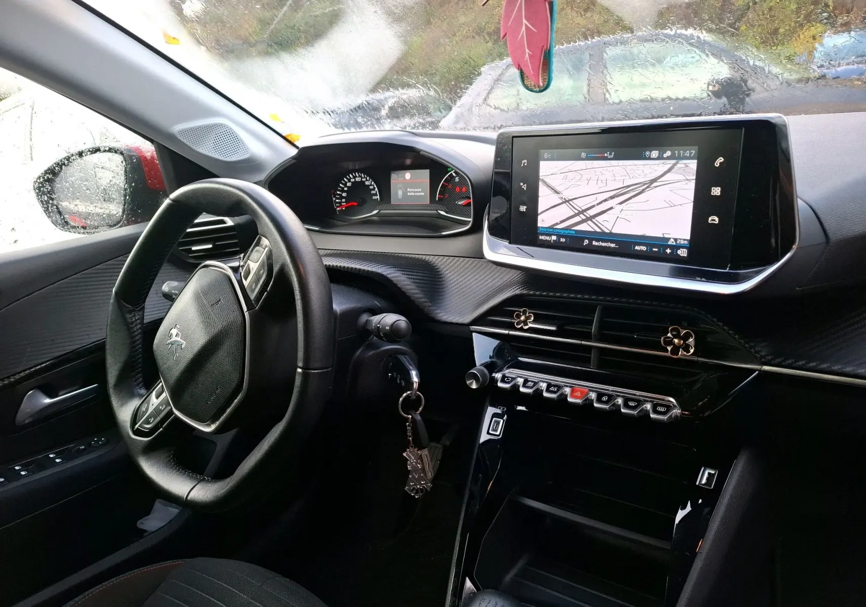 Vue intérieure côté conducteur de la Peugeot 208 1.5 BlueHDi 100 Active Business avec écran GPS et volant cuir noir.