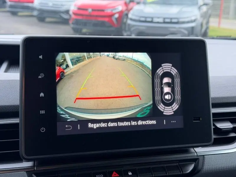 Écran tactile intérieur montrant la caméra de recul du Nissan Townstar blanc minéral, vue arrière avec lignes de guidage colorées.