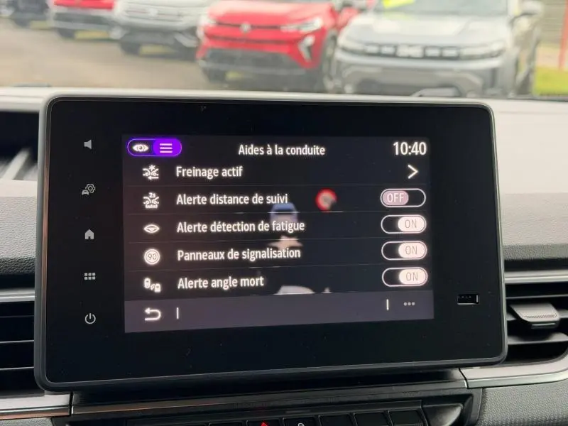 Écran tactile central du Nissan Townstar L1 EV 2024 affichant les aides à la conduite, vue intérieure frontale.