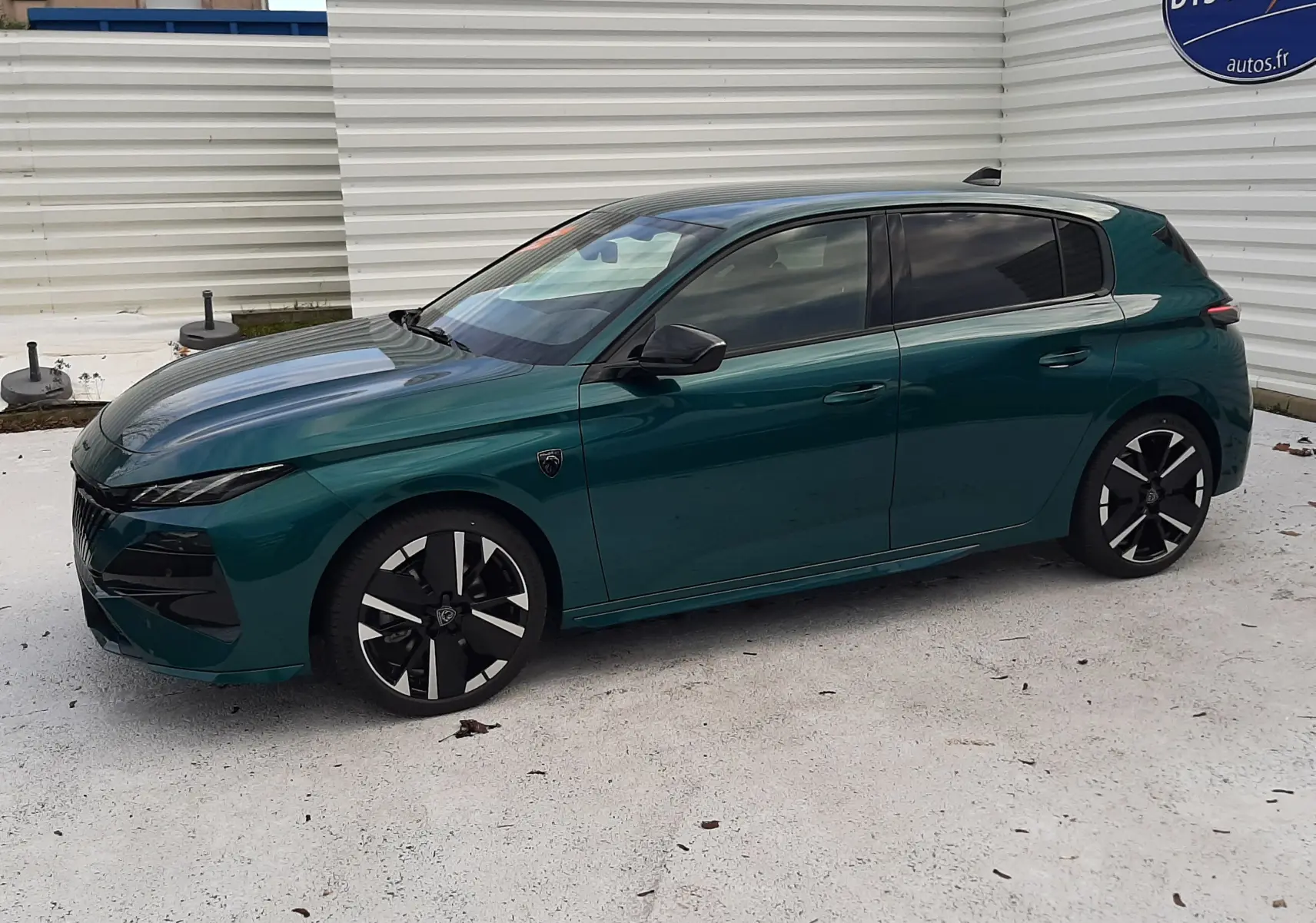 Peugeot 308 1.2 Hybrid 145ch GT bleu Lagoa vue de profil côté gauche, jantes noires et toit noir brillant.